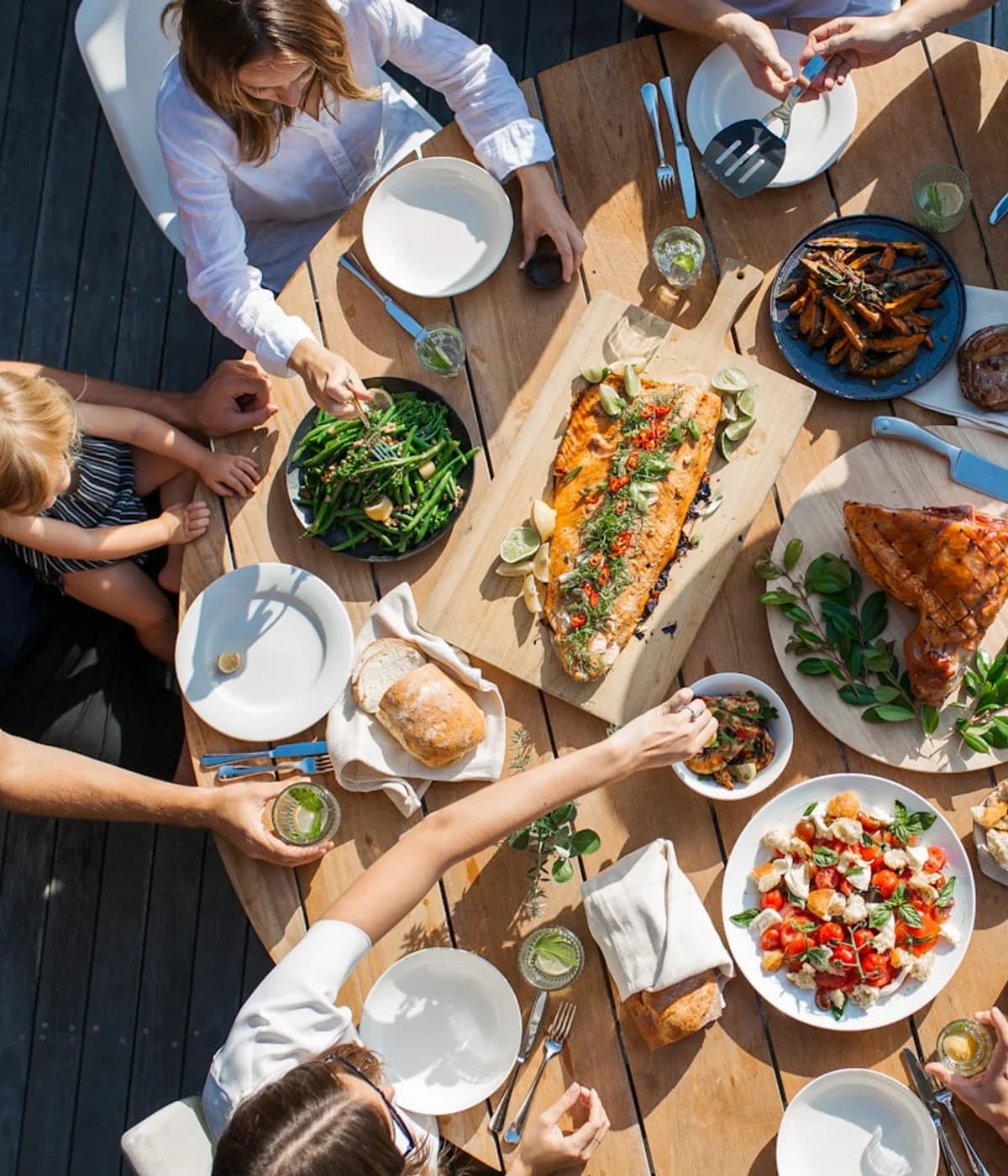 Persone che condividono un pranzo intorno a una tavola all’aperto. Fotografia d’ispirazione.